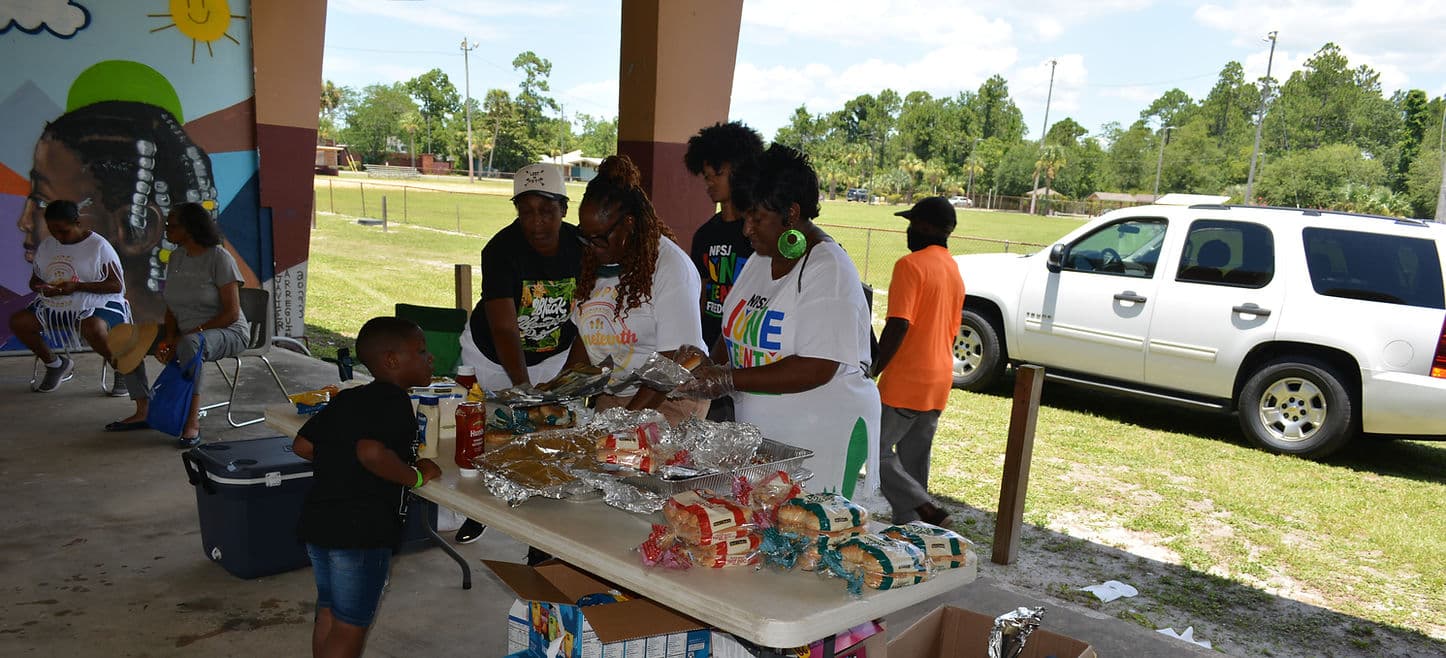 Outdoor community gathering with North Port St. Joe residents and neighbors under a tent