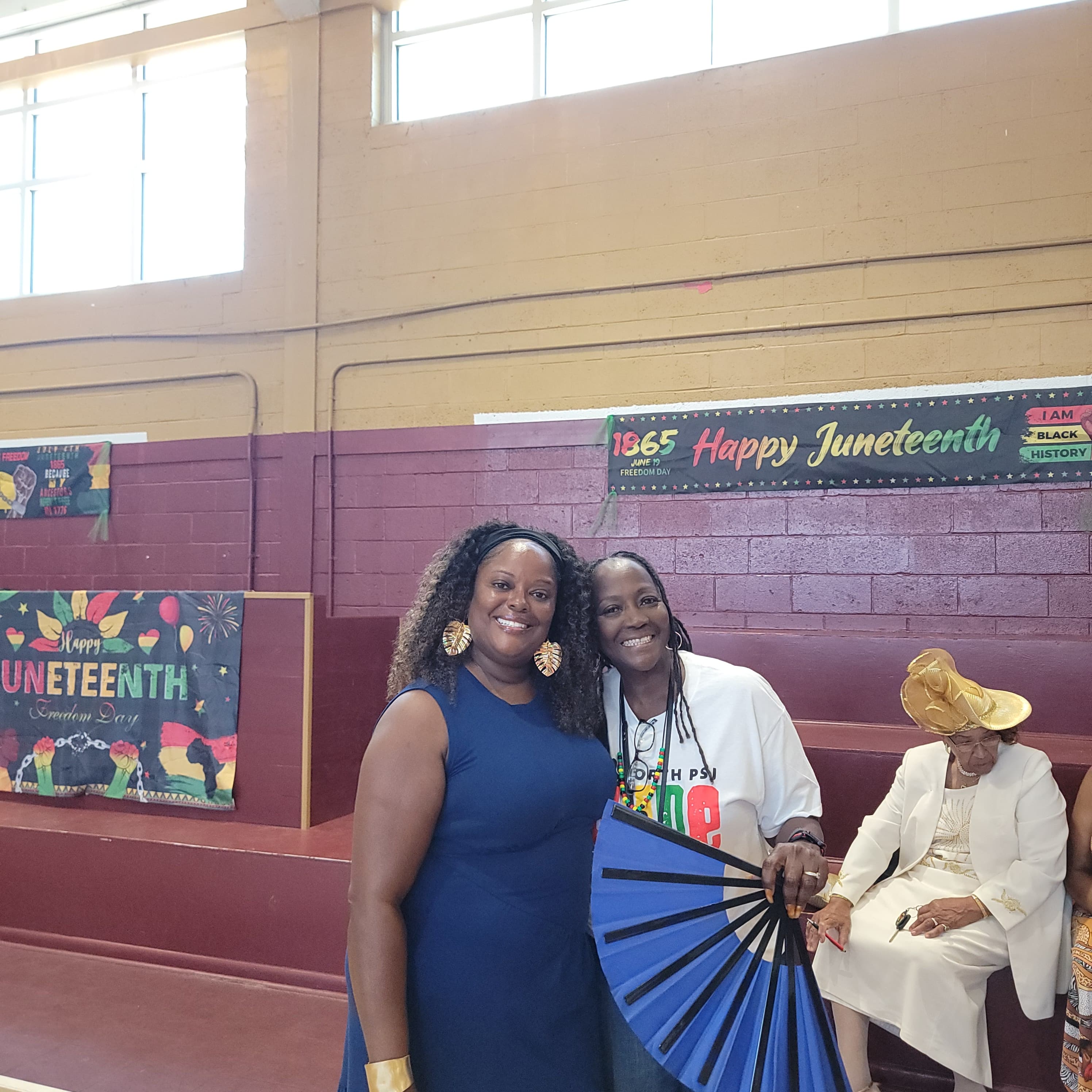 Attendees posing in front of the Happy Juneteenth banner