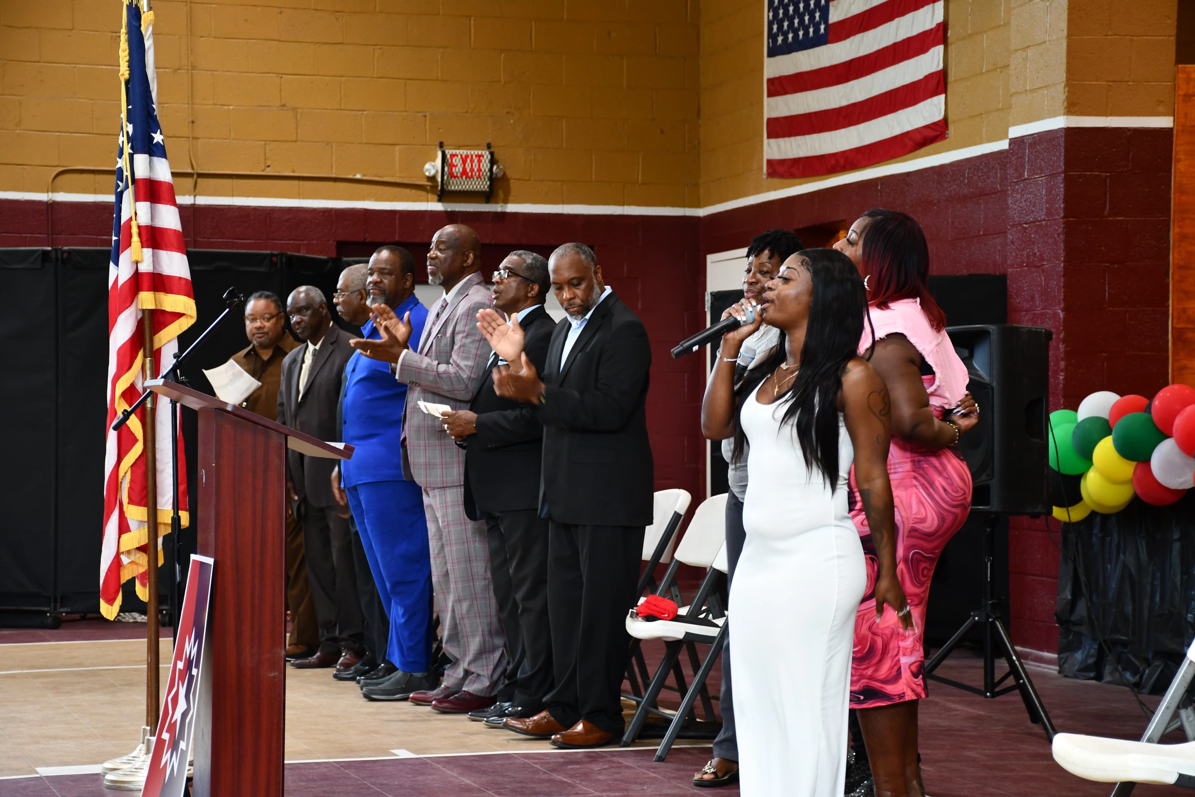 Community leaders and singers standing together during a musical selection at the Juneteenth ceremony