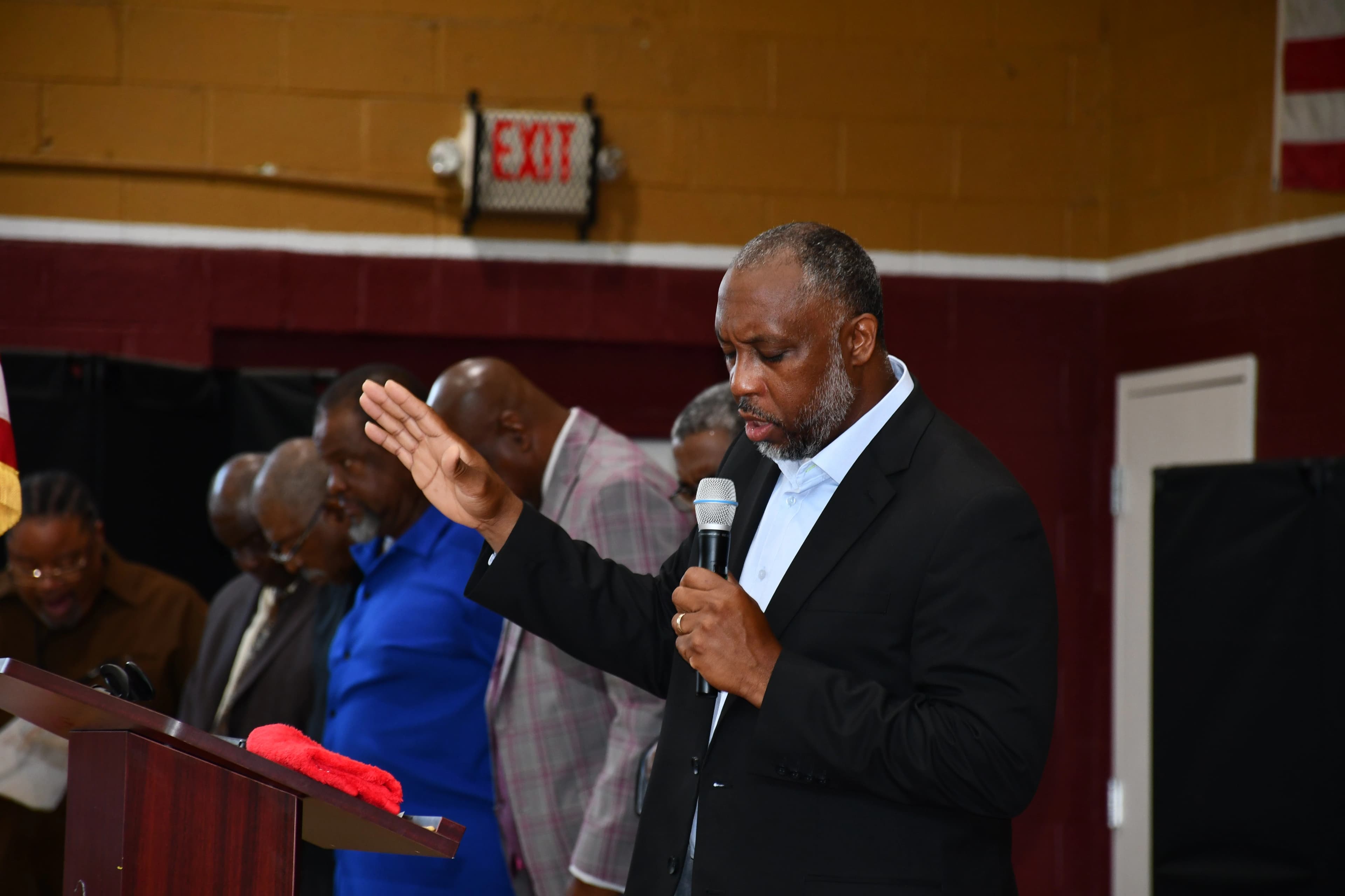 A community leader offering prayer at the podium during the Juneteenth ceremony