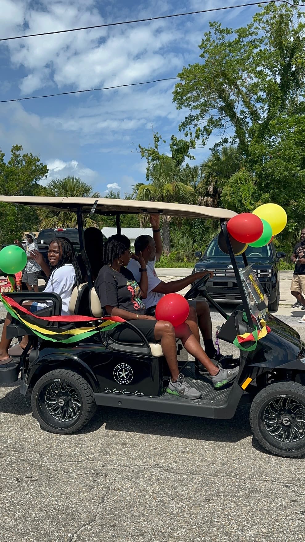 Golf cart decorated with Juneteenth balloons and colors participating in the parade