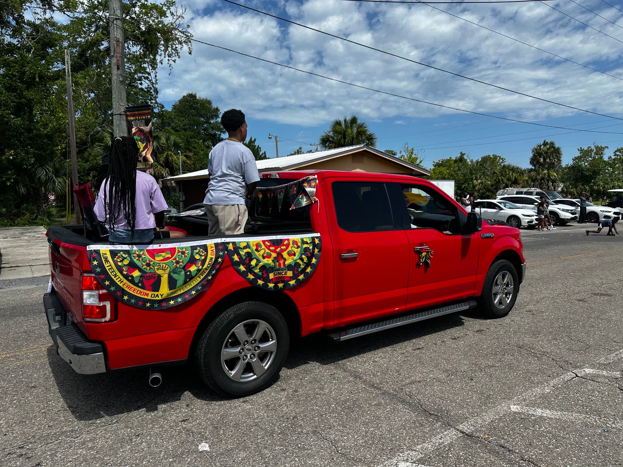 Red pickup truck decorated with Juneteenth Freedom Day bunting in the parade