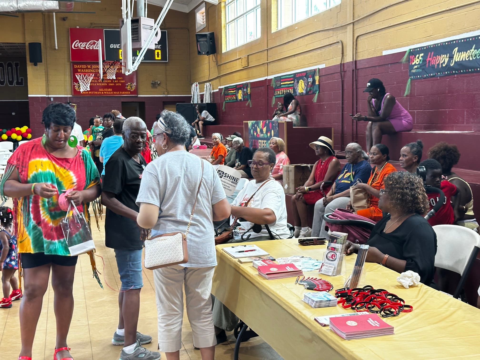 Community members at a resource table inside the Washington High School gymnasium
